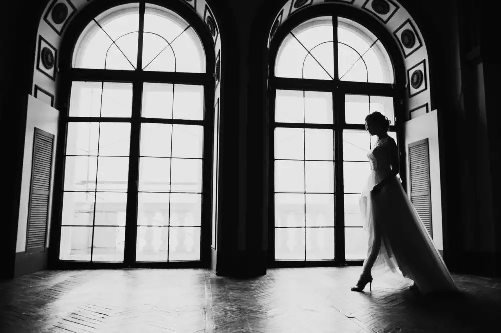 Фотосессия невесты в большом зале с красивыми окнами