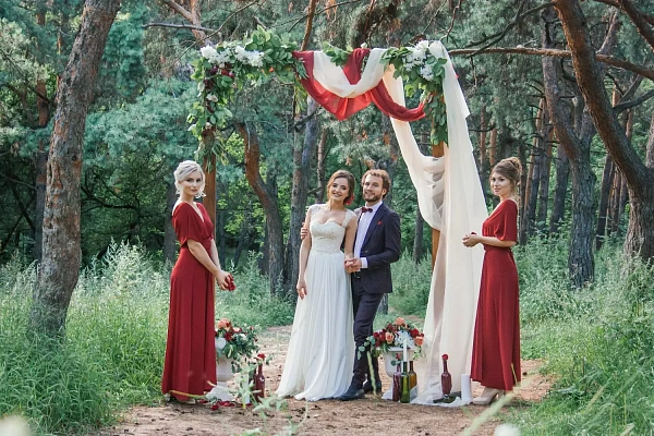 Церемония бракосочетания и подружки невесты под алтарем в лесу. Фото 1